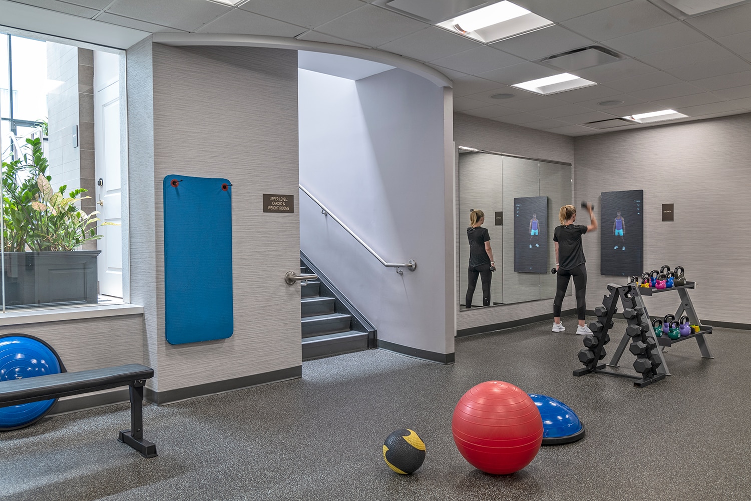 First Floor of 24 hours fitness center features three Echelon Reflect Touch mirrors, stretching area, and more. 